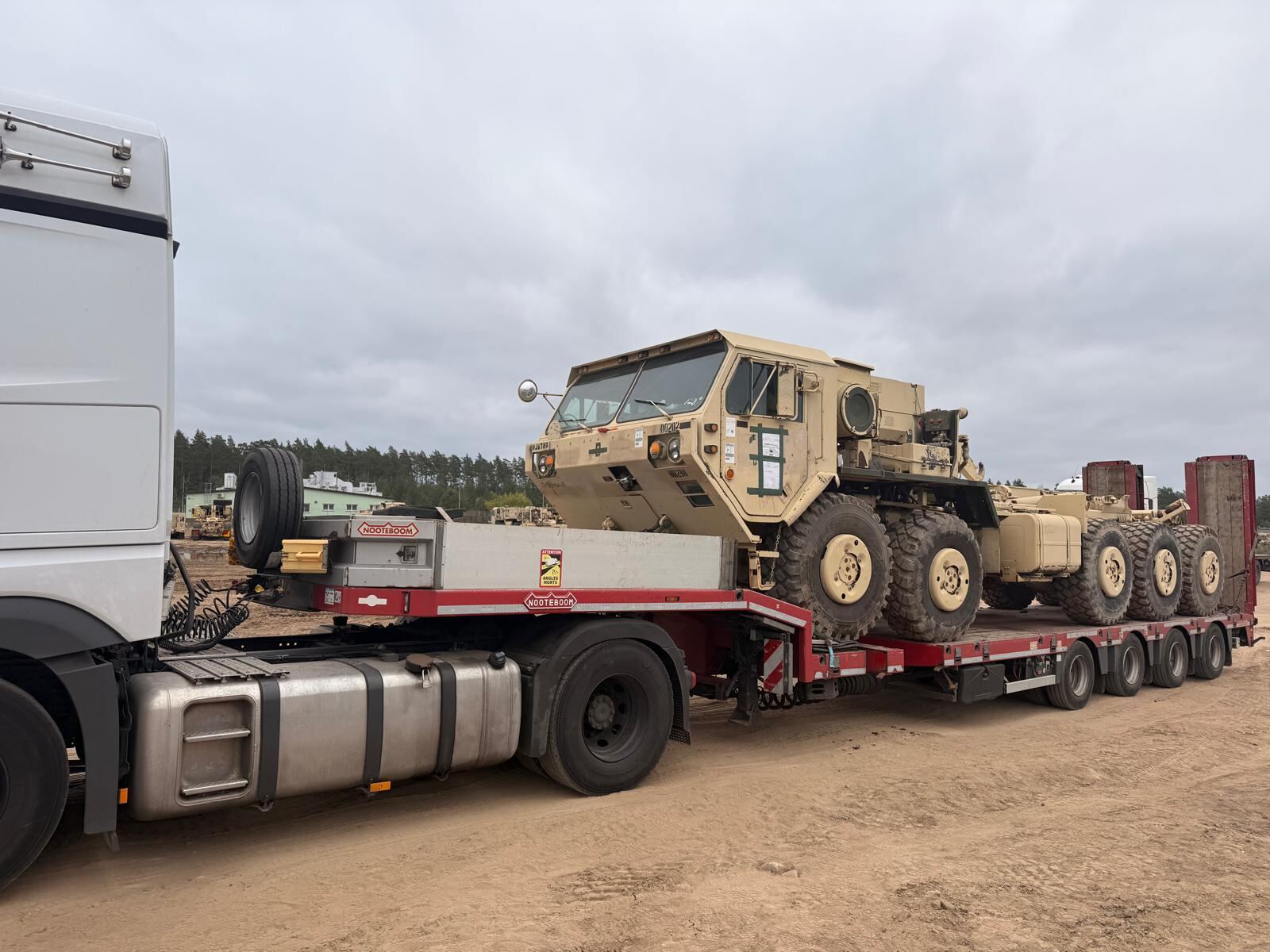 Heavy tactical trucks in convoy on a gravel road