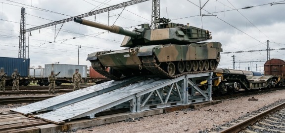 Main battle tank driving off a rail flatcar over a modular Ro/Ro ramp