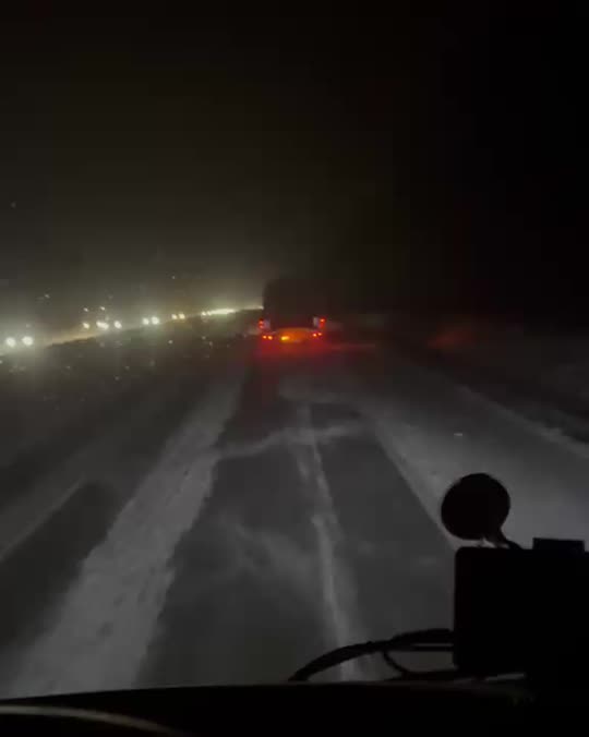 Headlights of the convoy on an open road at night